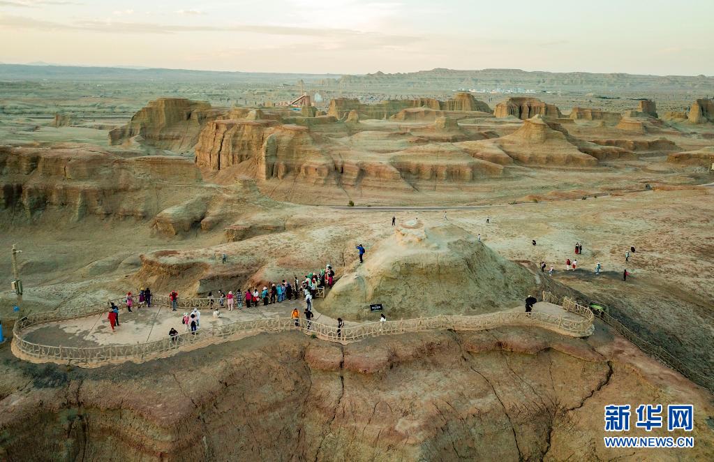 新疆ウイグル自治區(qū)カラマイ市ウルホ區(qū)にある世界魔鬼城景勝地で日沒(méi)を眺める観光客ら（6月21日にドローンで撮影?顧煜）。