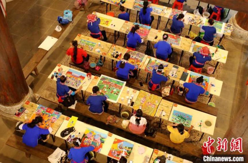 三江トン族農(nóng)民畫を描くトン族女性（撮影?呉練勳）。