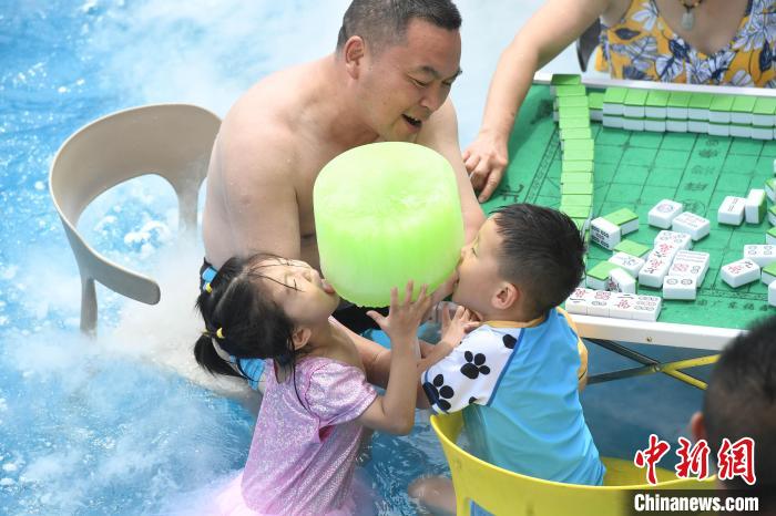 プールにつかりながら、特製の巨大アイスキャンディーを食べる子供（撮影?陳超）。