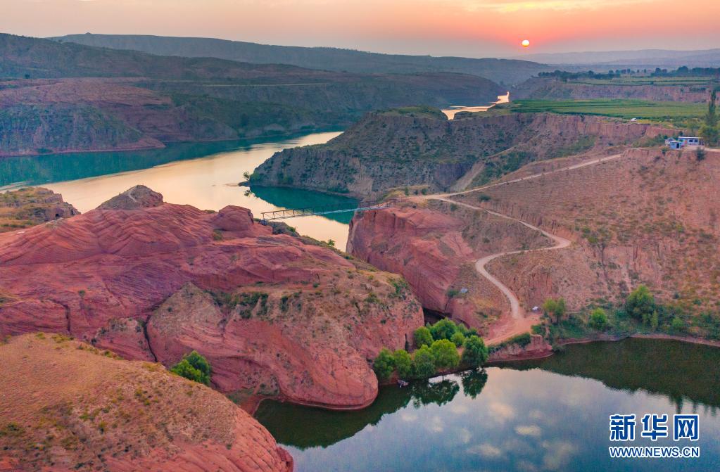 8月6日、朝焼けに染まる陝西省靖辺県竜洲鎮(zhèn)の波浪谷丹霞景勝地（ドローンよる撮影?陶明）。