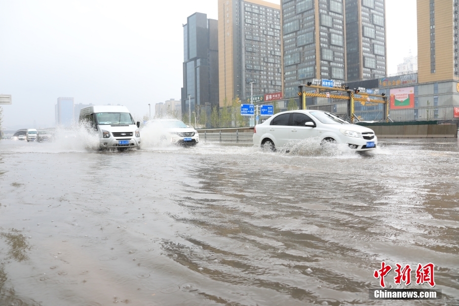 鄭州市市街地で、冠水した道路を走行する車両（撮影?闞力）。