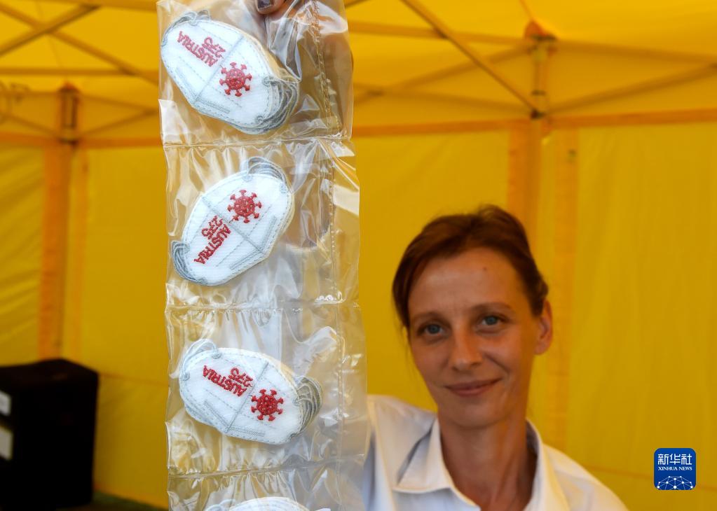 9月16日、オーストリアのウィーンで「ミニマスク」デザインの切手を見せるオーストリア郵便局のスタッフ（撮影?郭晨）。