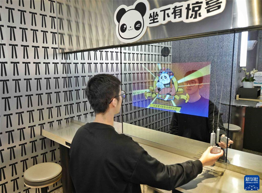 15日、ケンタッキーのAIパンダスマートテレビ體験コーナーで雙方向のコンテンツを楽しむ人。（撮影?劉坤）