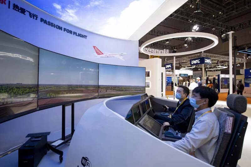 技術(shù)裝備エリアの米ハネウェル社の展示ブース「飛行を愛する」では、來場者が飛行シミュレータに乗って、空を飛ぶ楽しさを體験していた。シミュレータにはハネウェルの航空輸送分野における複數(shù)の革新的製品?技術(shù)が搭載され、そのうち空港での滑走誘導(dǎo)システムと滑走路から外れた時の警告システムはどちらも世界初公開だ。（撮影?翁奇羽）