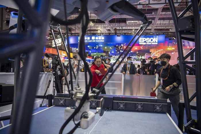 技術(shù)裝備エリアで、卓球ロボット「FORPHEUS」と白熱した試合を繰り広げた元卓球世界チャンピオンの李暁霞選手（寫真左）と來場者のペア（11月6日撮影?翁奇羽）。