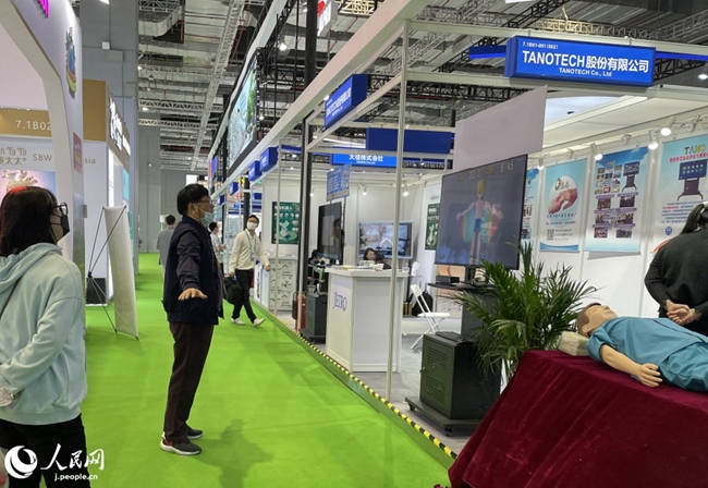 非裝著?非接觸型自立支援ツール「TANO」を體験する來場(chǎng)者（撮影?張麗婭）。