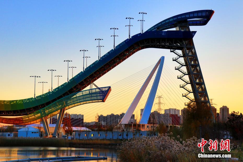 夕陽(yáng)に映える北京冬季五輪公園の首鋼ジャンプ臺(tái)と首鋼大橋