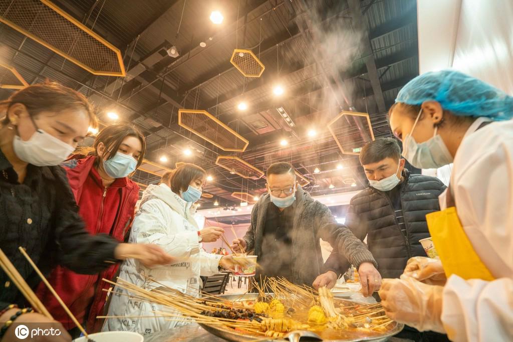 12月3日、新疆維吾爾（ウイグル）自治區(qū)庫爾勒（コルラ）市蘭乾郷蘭乾村香梨ナン産業(yè)園ナイトマーケットで、食べ物を購入する市民（寫真著作権は東方ICが所有のため転載禁止）。