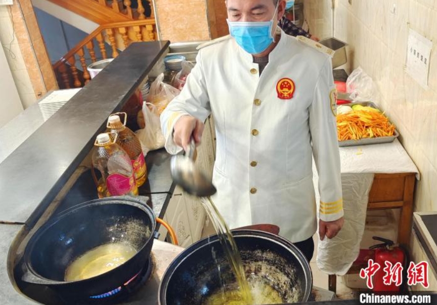 熱したフライパンに油を注ぐ（撮影?史玉江）。