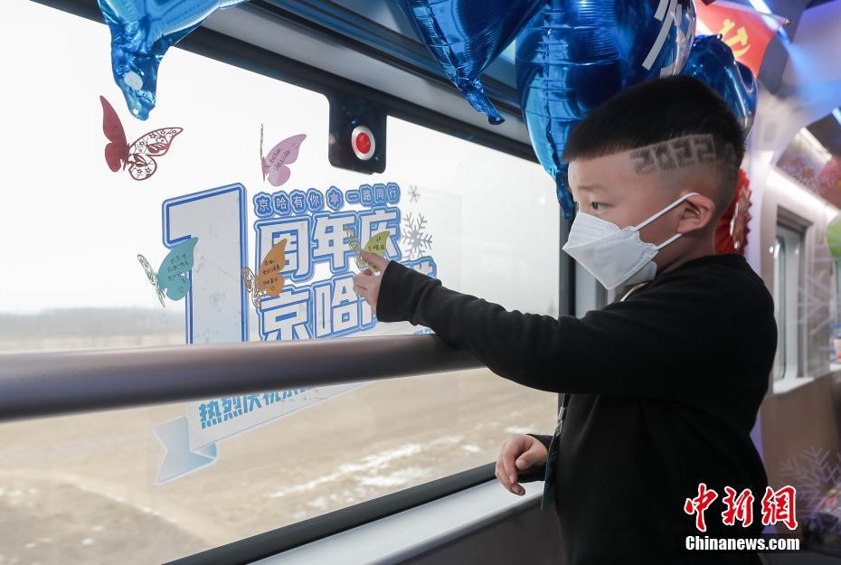 北京朝陽駅発ハルビン西駅行G901號車の車內(nèi)で、車窓にお祝いの言葉を貼り付ける子供（1月22日撮影?賈天勇）。