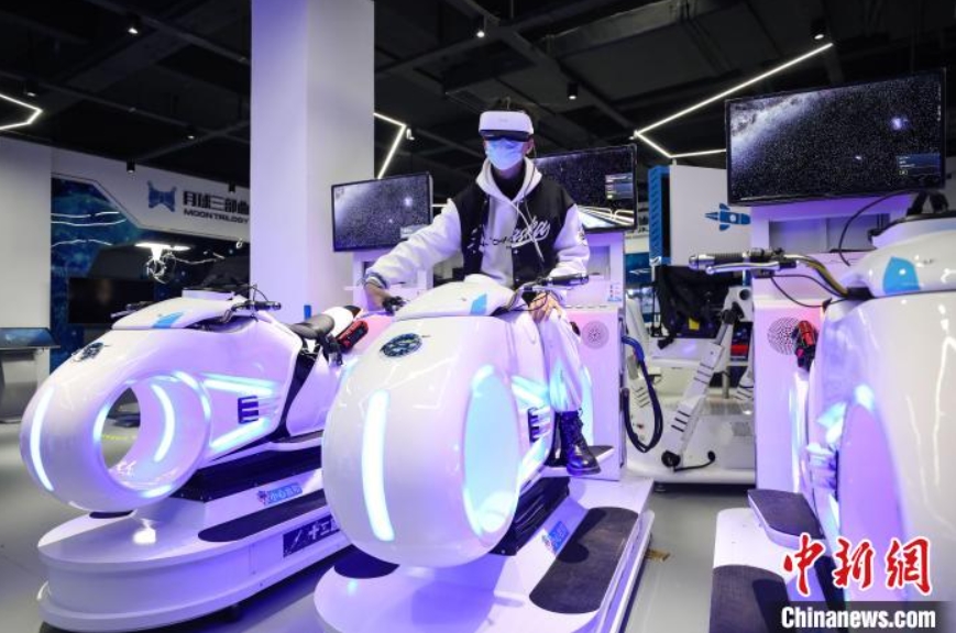 バーチャル?リアリティ（VR）で近未來型バイクを體験する男性（撮影?瞿宏倫）。