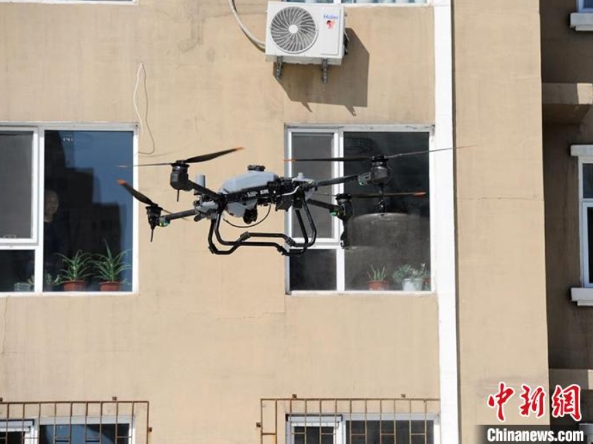 上空から消毒液を散布するドローン（撮影?劉棟）。