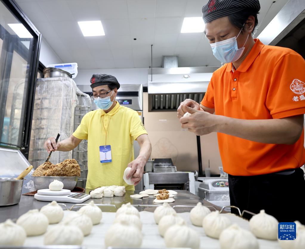 4月10日、営業(yè)を再開した上?！咐鲜⒉剐旖瓍^(qū)梅隴路店で、忙しく立ち働く店員の黃慶さん（寫真右）と任海さん（撮影?陳建力）。