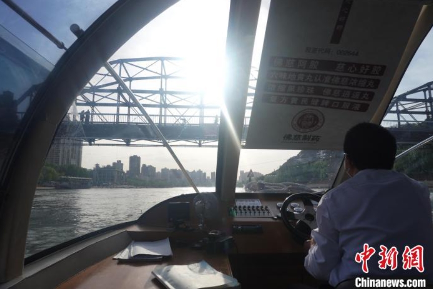 「百年鉄橋」の下を通過(guò)する水上バス（撮影?九美旦増）。