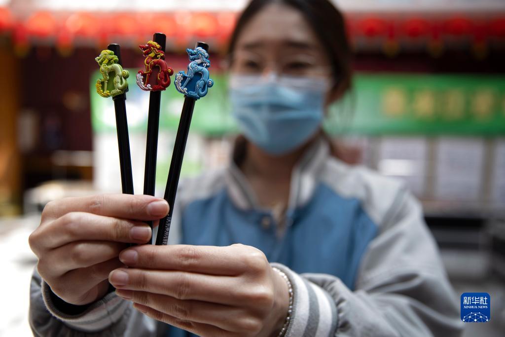 黒竜江省博物館で、「銅座竜」がデザインされたサインペンを見せる職員（5月16日撮影?張濤）。