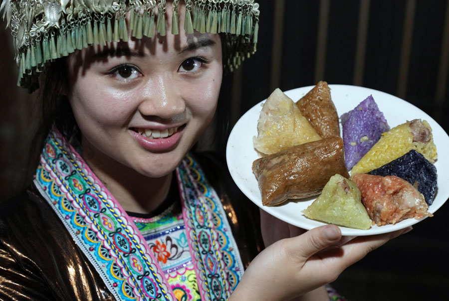 5月22日、広西壯（チワン）族自治區(qū)柳州市融水苗（ミャオ族）自治県夢嗚苗寨で、彩色ちまきを見せるミャオ族の女性（寫真著作権は東方ICが所有のため転載禁止）。