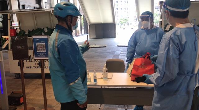 5月21日、複合商業(yè)施設(shè)?興業(yè)太古匯の外で、商品を受け取るために、「場所コード」を提示するデリバリー配達(dá)員（撮影?周蕊）。