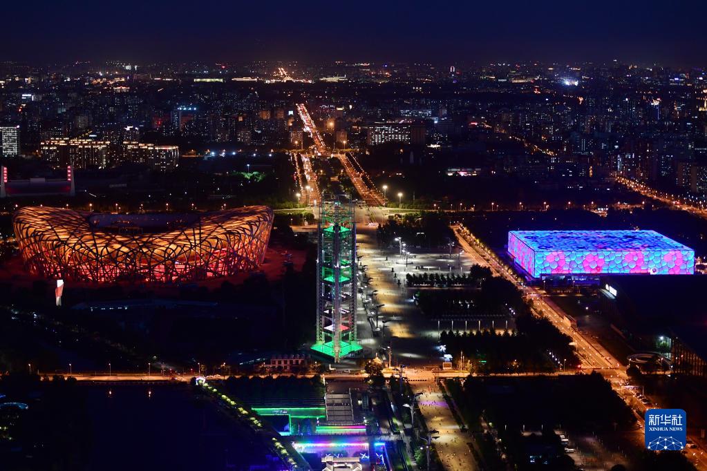 ライトアップされた國(guó)家體育場(chǎng)（寫(xiě)真左）と國(guó)家水泳センター（ウォーターキューブ、6月23日撮影?張晨霖）。