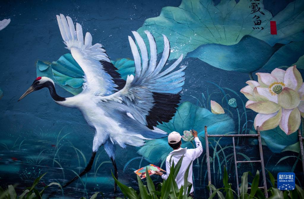 雲(yún)南省麗江市永勝県三川村で、壁畫を制作する劉志誠さん（6月24日撮影?江文耀）。