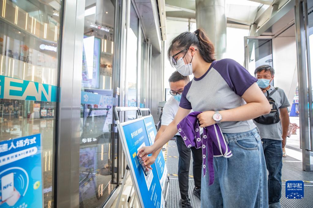 重慶両江新區(qū)のショッピングパークで、NFC機(jī)能を使って入場(chǎng)するための登録を終える買物客（7月4日撮影?黃偉）。