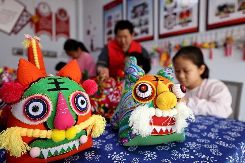 7月6日、山東省棗荘市竜山路街道（エリア）にある民間技能伝承者?王欣さんのアトリエで、布製「虎」の作り方を?qū)Wぶ子供たち（寫真著作権はCFP視覚中國(guó)が所有のため転載禁止）。