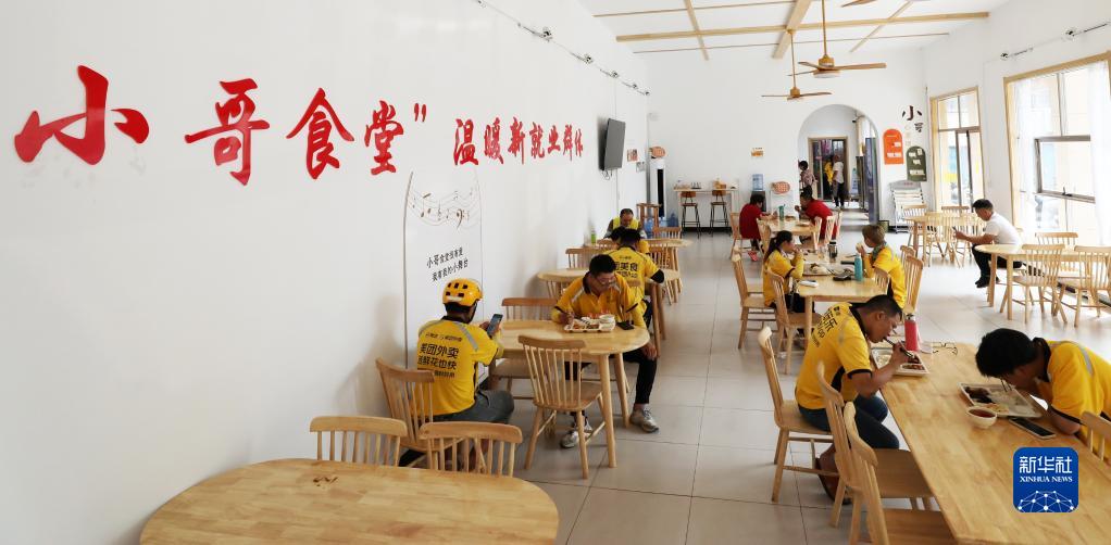 山東省臨沂市郯城県郯城エリア竜泉コミュニティの「小哥食堂」で、食事をとるデリバリー配達(dá)員（7月9日撮影?張春雷）。