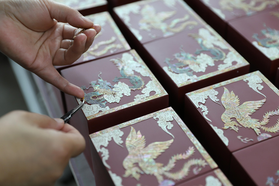 7月13日、山東省青島市西海岸新區(qū)にある青島紫貝工蕓品有限公司の工房で、漆器に花の飾りをあしらう螺鈿漆器工蕓伝承者（寫真著作権は東方ICが所有のため転載禁止）。