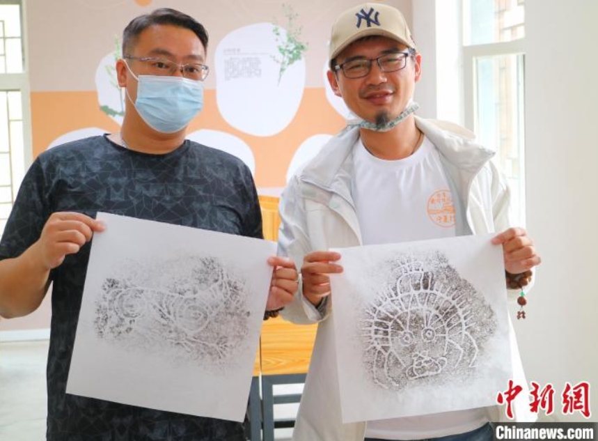 自分でとった巖畫拓本を見せる臺(tái)灣地區(qū)出身の若者（撮影?李元昊）。