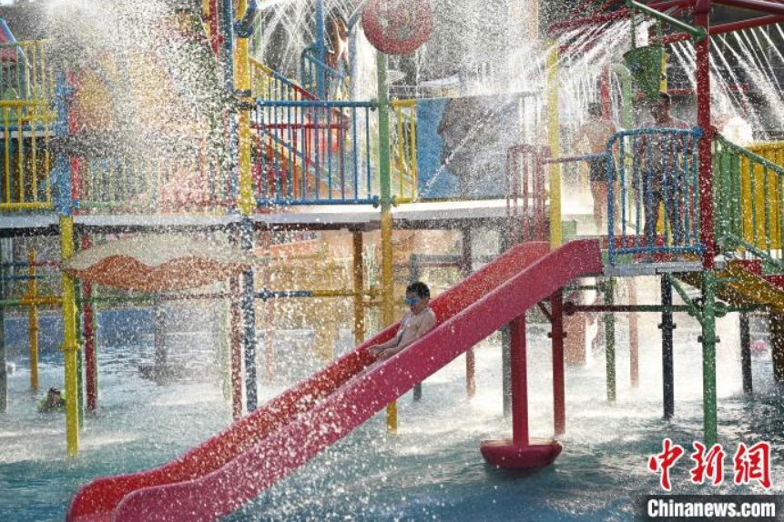 プールに設(shè)置されている滑り臺(tái)で遊ぶ子供（撮影?陳超）。