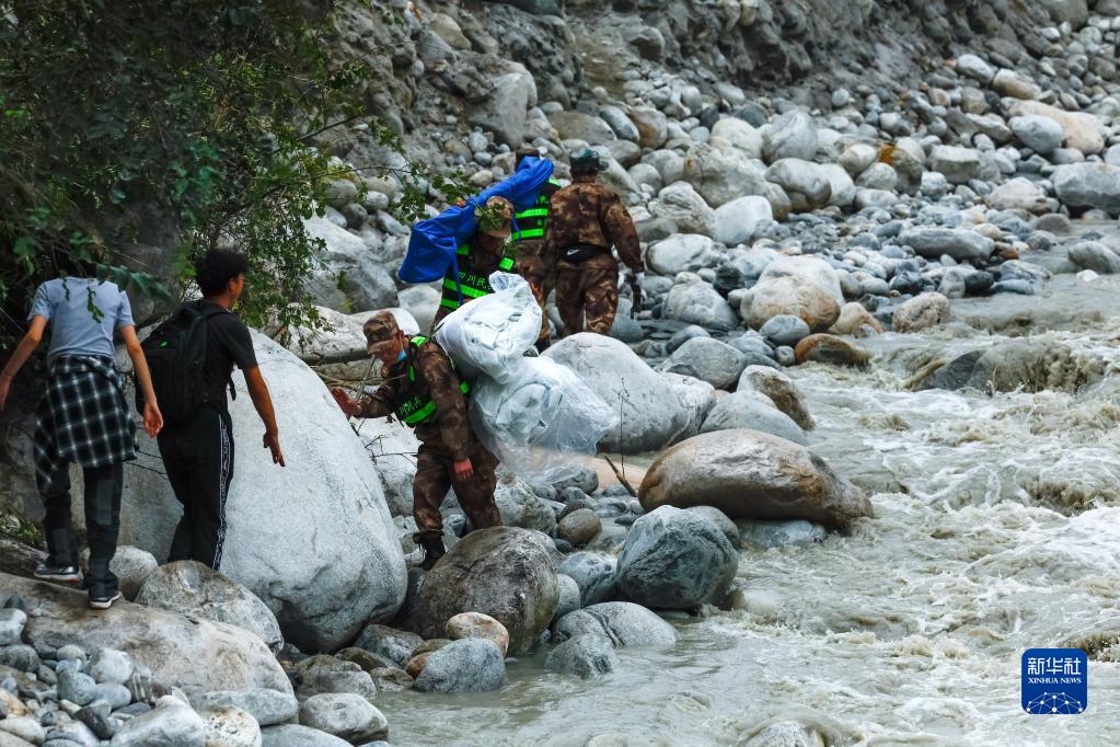 四川瀘定地震　背負い、擔いで物資屆ける救援隊員とボランティア