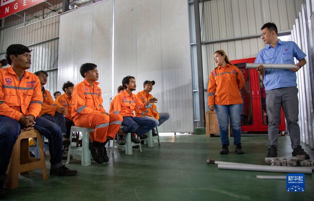 インドネシア?バンドンで、中國標(biāo)準(zhǔn)「簡統(tǒng)化（簡単?統(tǒng)一?標(biāo)準(zhǔn)化）」の架空送電線取り付け作業(yè)をインドネシア人スタッフに説明する中國中鉄電気化局の王浩さん（寫真右端、11月13日撮影?焦宏濤）。