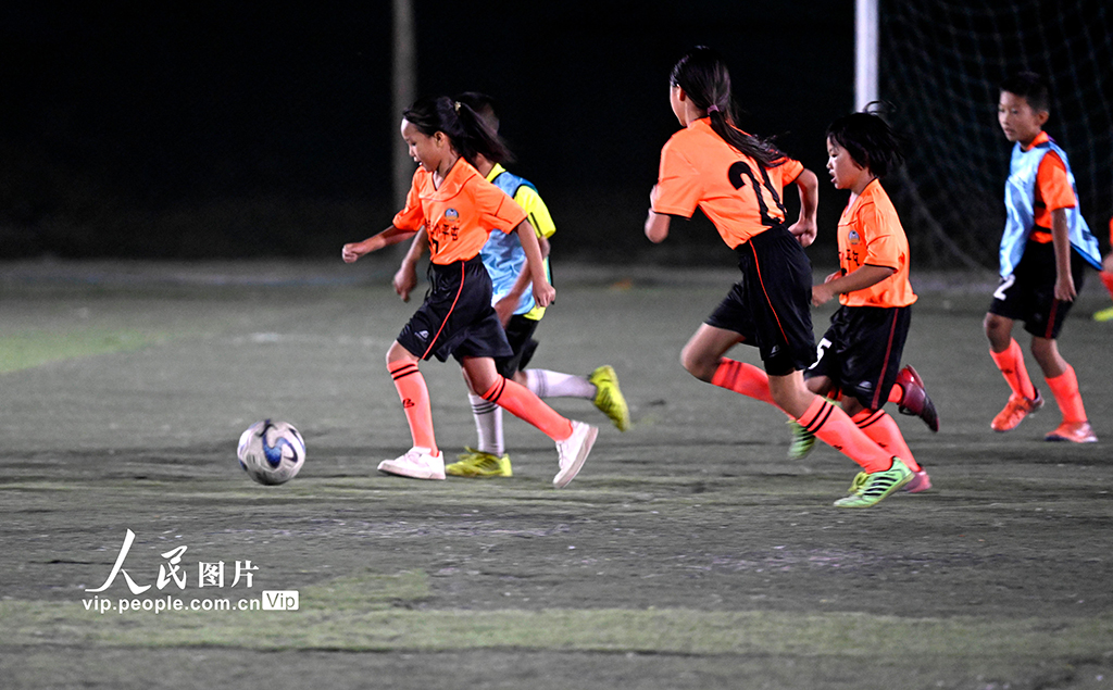 夜間照明のあるサッカーグラウンドでサッカーの夢育む農(nóng)村の子供たち　広西柳江