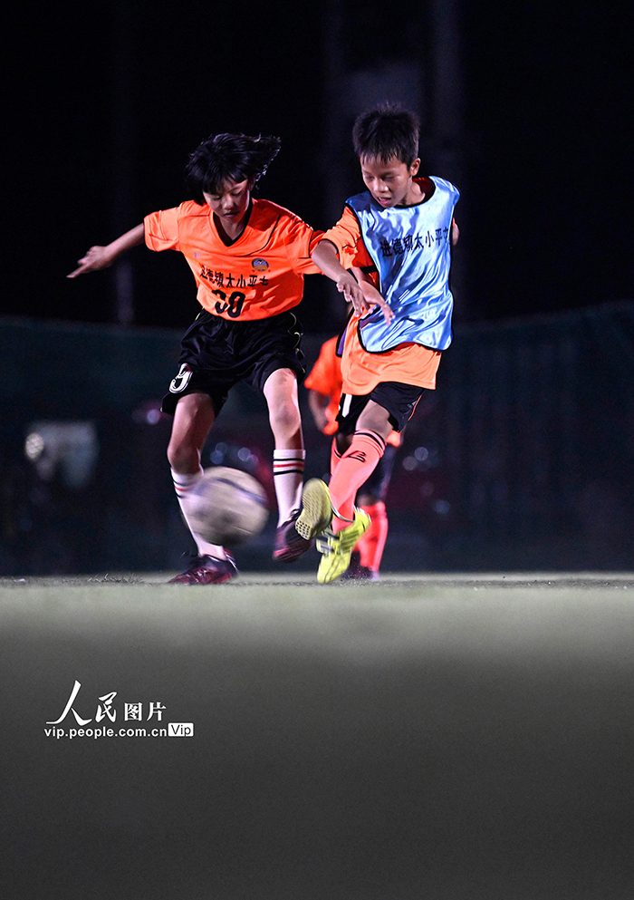 夜間照明のあるサッカーグラウンドでサッカーの夢育む農(nóng)村の子供たち　広西柳江