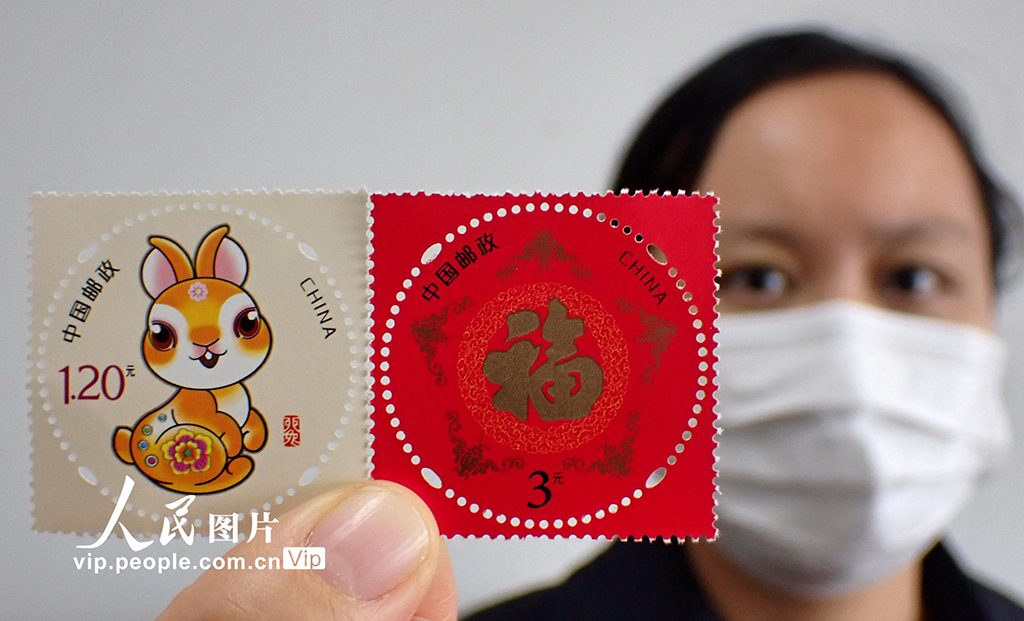 江蘇省張家港市郵政局で購入した2023年度の年賀記念切手を見せる市民（11月15日撮影?施柏栄/寫真著作権は人民図片が所有のため転載禁止）。
