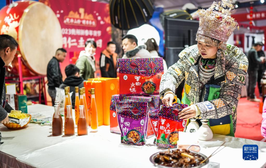 貴陽市南明區(qū)蘭花広場の年越し用品會場で、商品を並べる少數(shù)民族衣裝姿のスタッフ（1月15日撮影?陶亮）。