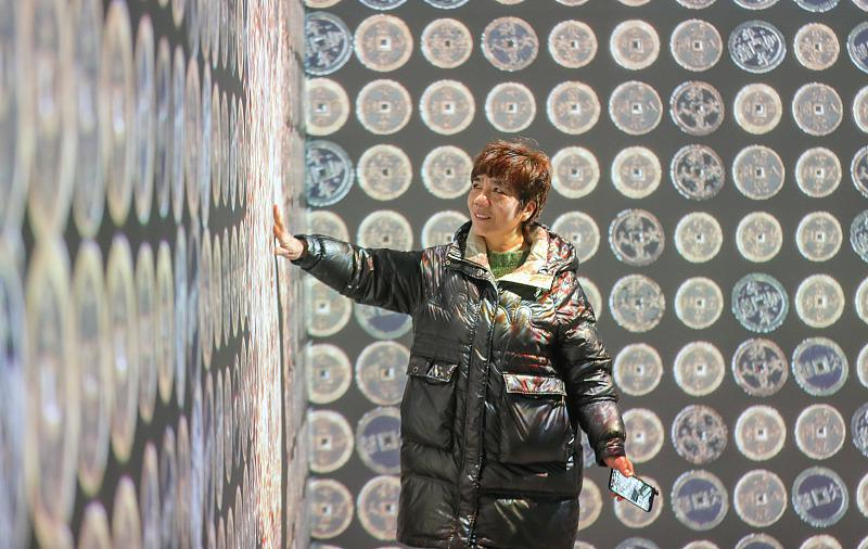 2月6日、浙江省湖州市徳清県乾元鎮(zhèn)の銭幣珍蔵館で、沒(méi)入型古銭光影展を見(jiàn)學(xué)する來(lái)館者（寫真著作権はCFP視覚中國(guó)が所有のため転載禁止）。