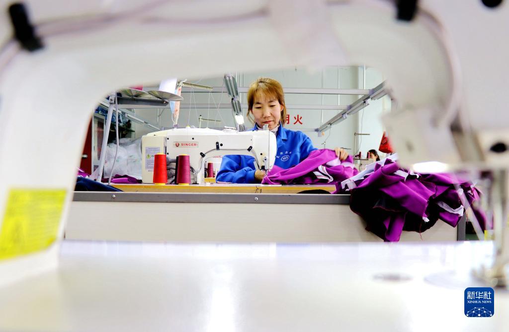 甘粛省平?jīng)鍪徐o寧県城関鎮(zhèn)南関村の衣料品工場(chǎng)で縫製作業(yè)を行う作業(yè)員 (2月13日撮影?王毅)。