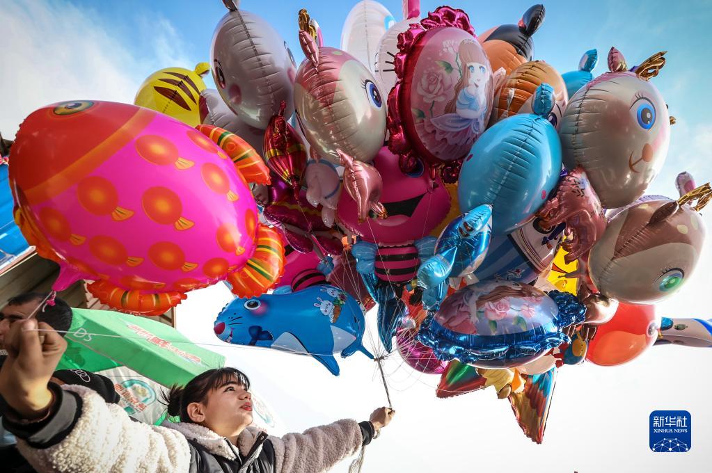 托克扎克鎮(zhèn)の自由市場(chǎng)で、買物客の風(fēng)船を選ぶ販売員（2月26日撮影?馬鍇）。