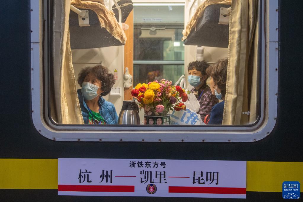 乗車後、自ら持參した花を座席に飾る乗客（3月10日撮影?江漢）。