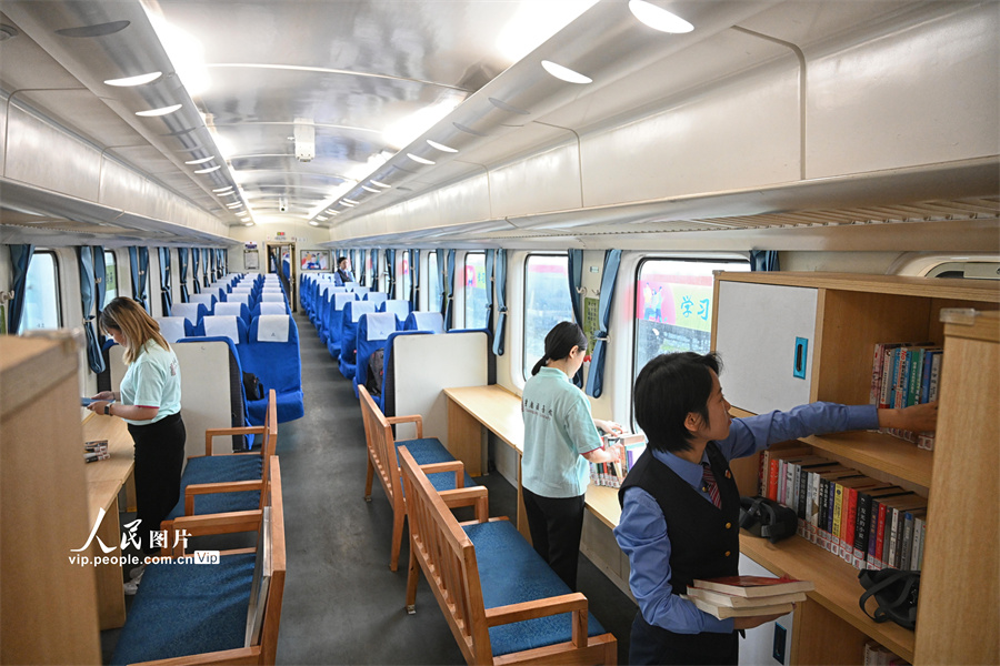 列車図書室で、書籍の整理作業(yè)の仕上げを行う、中國鉄路成都局重慶旅客輸送區(qū)間と重慶図書館のボランティア（撮影?龍帆/寫真著作権は人民図片が所有のため転載禁止）。