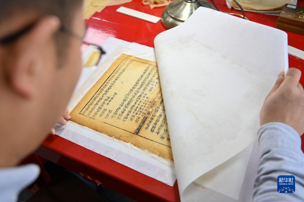 古書の「低侵襲手術」を行う若者　山西省