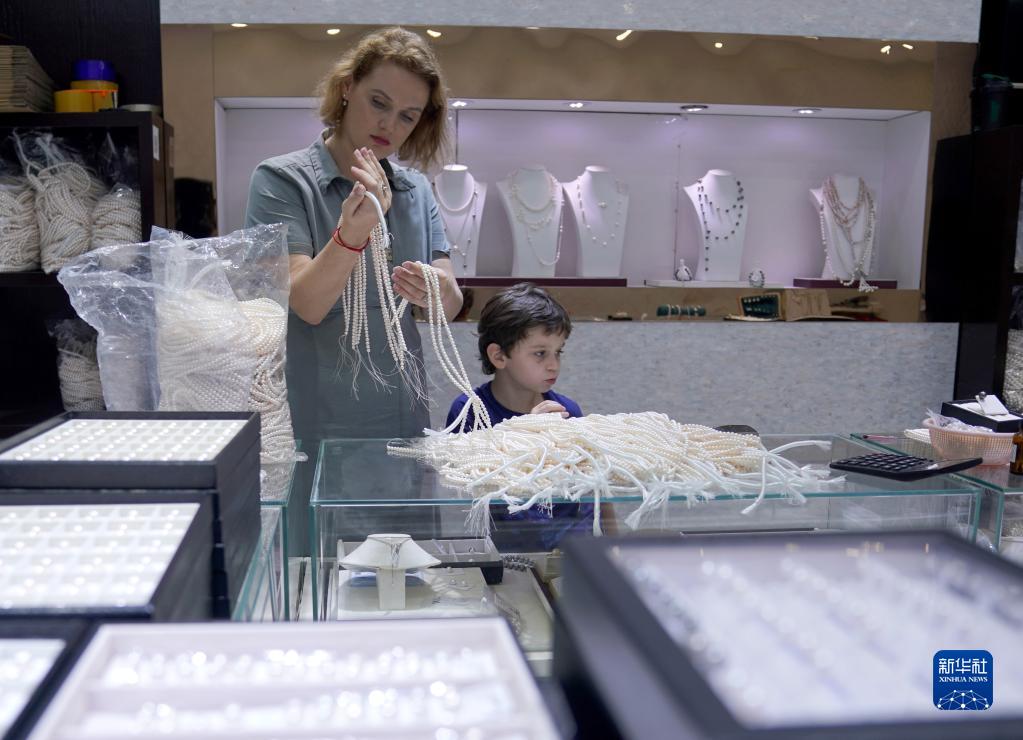 浙江省諸曁市山下湖鎮(zhèn)華東國際珠寶城で、真珠のネックレス選ぶロシア人の親子連れ（5月17日撮影?韓伝號）。
