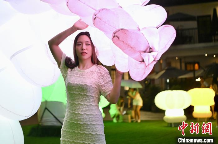 巨大なインスタレーションである「機(jī)械植物」と「交流」する女性（撮影?李志華）。