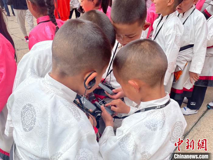    仲間と一緒に音聲ガイドデバイスをいじる俄金仁増くん（撮影?袁秀月）。