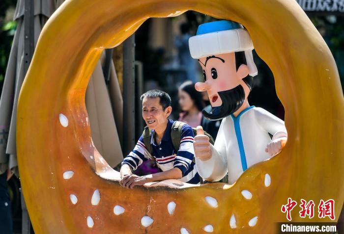 維吾爾民話の登場人物「阿凡提（エペンディ）」と記念寫真を撮る観光客（撮影?劉新）。