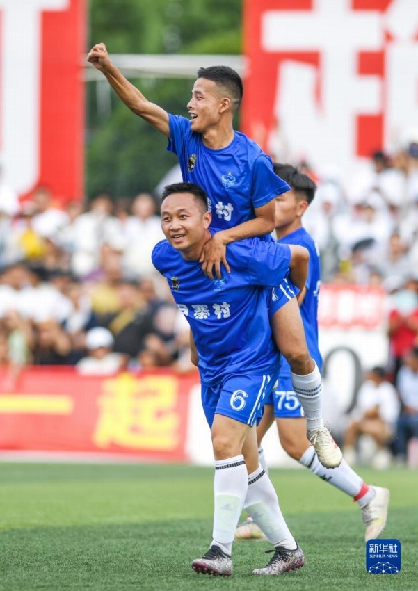 シュートが決まりチームメイトを背負って喜ぶ月寨村チームの李遠攀選手（寫真前、7月15日撮影?楊文斌）。