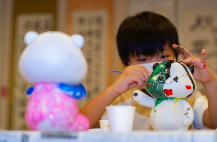 パンダの人形に色を塗る男の子。（8月16日撮影?張笑宇）。