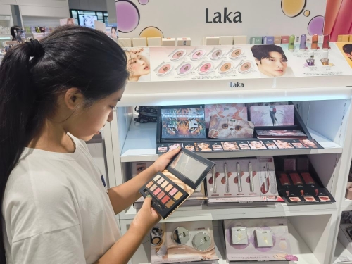 中國(guó)のコスメブランド「完美日記（パーフェクトダイアリー）」のアイシャドウを手にする消費(fèi)者。