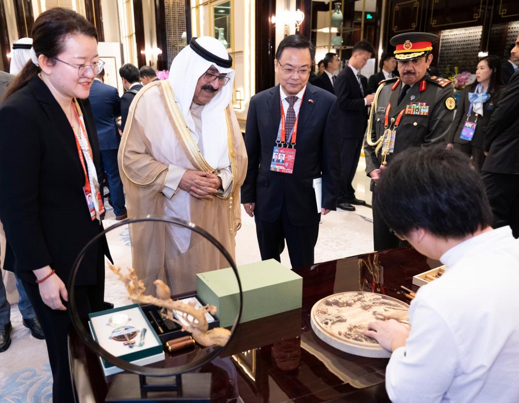 「東陽木彫」を鑑賞するクウェートのミシュアル皇太子(撮影?黃敬文)