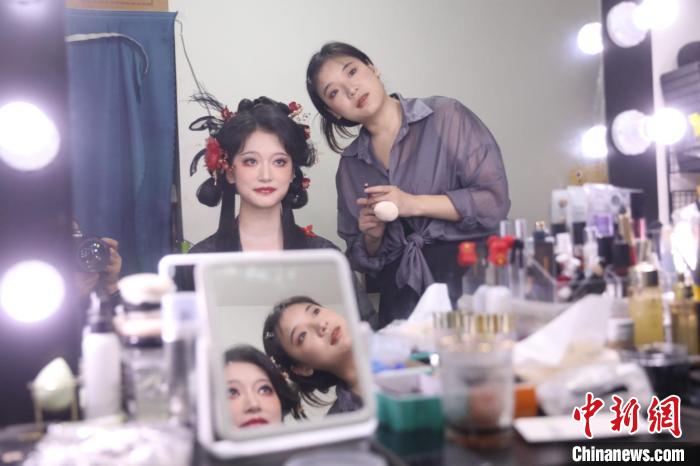 四川省成都市にある漢服メイク?ヘアセットスタジオで、モデルのメイクとヘアセットをチェックする漢服メイク?ヘアセットアーティストの李金芝さん（寫真右、9月26日撮影?王磊）。